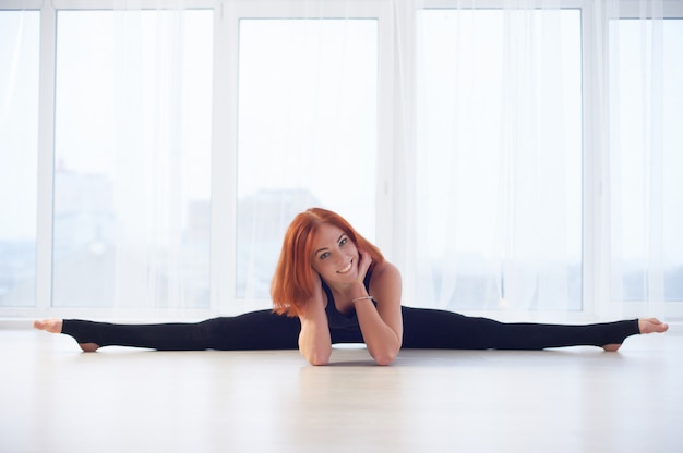 Hermosa mujer practica yoga asana Samakonasana Postura de ángulo recto en el estudio de yoga.