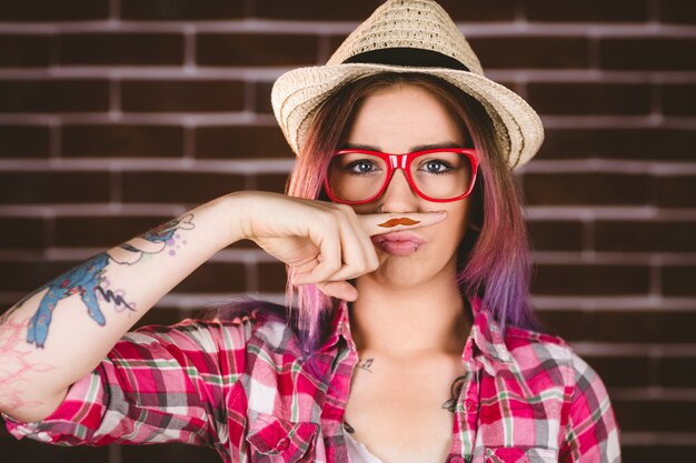 Hermosa mujer pretendiendo tener un bigote falso