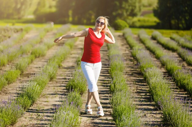 Hermosa mujer provenzal relajándose en el campo de lavanda viendo la puesta de sol sosteniendo una cesta con flores de lavanda. dama rubia en campo de flores