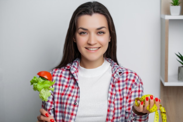 Hermosa mujer que elige entre alimentos útiles y nocivos