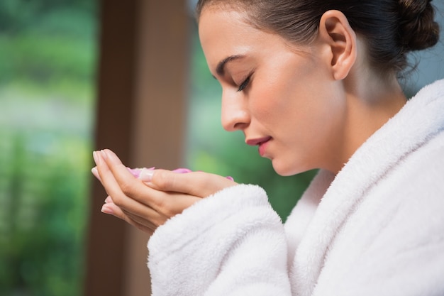 Hermosa mujer que huele flores en el spa