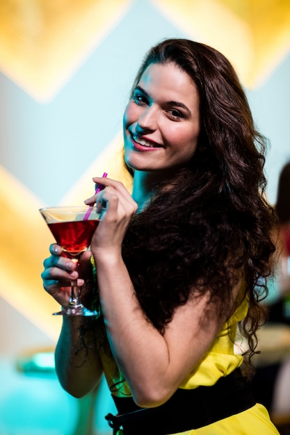 Foto hermosa mujer que tiene un martini rojo