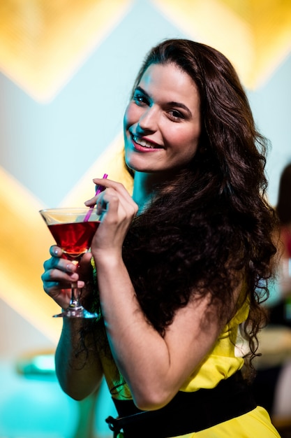 Hermosa mujer que tiene un martini rojo