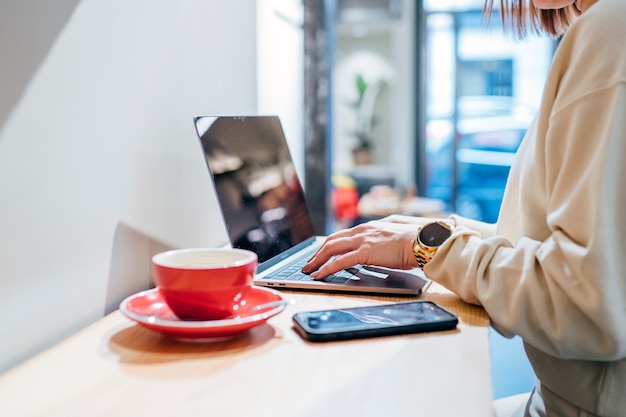 Foto hermosa mujer que trabaja con la computadora en la cafetería.