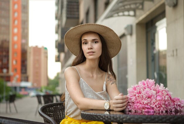 Hermosa mujer con un ramo de flores en la ciudad