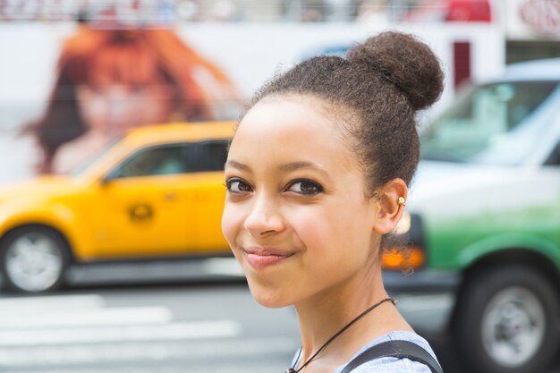 Foto hermosa mujer de raza mixta en la ciudad, retrato sonriente