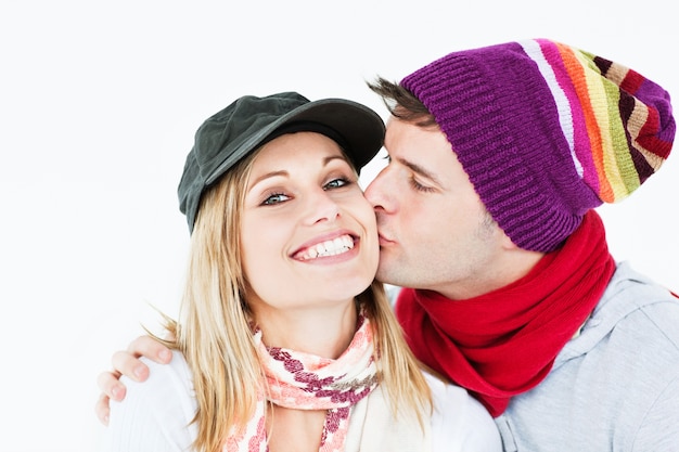 Hermosa mujer recibe un beso de su novio con gorra y sombrero