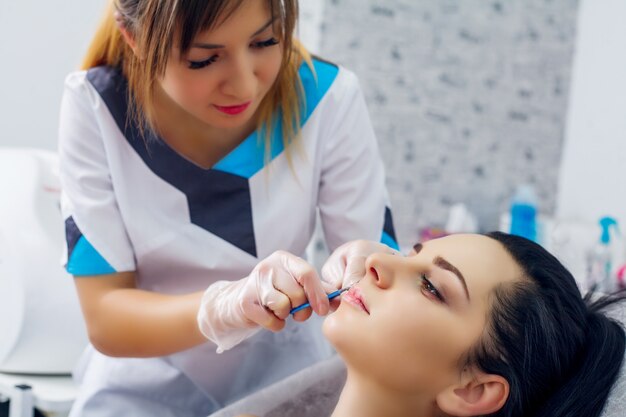 Hermosa mujer recibe inyecciones, cosmetología