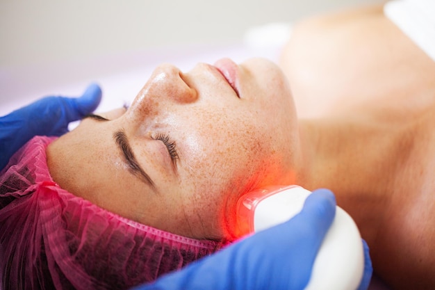 Hermosa mujer recibiendo masaje facial al vacío en el estudio de belleza