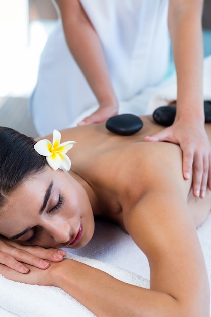 Hermosa mujer recibiendo masaje con piedras