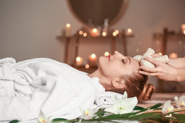 Hermosa mujer recibiendo masajes en el salón de spa