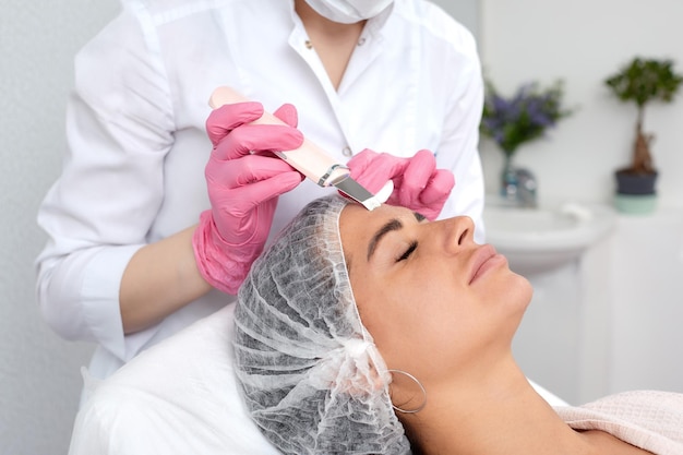 Hermosa mujer recibiendo ultrasonido cavitación peeling facial Cosmetología y cuidado de la piel facial