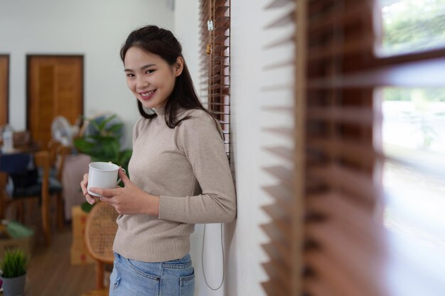 Hermosa mujer relajándose y bebiendo café por la mañana en casa