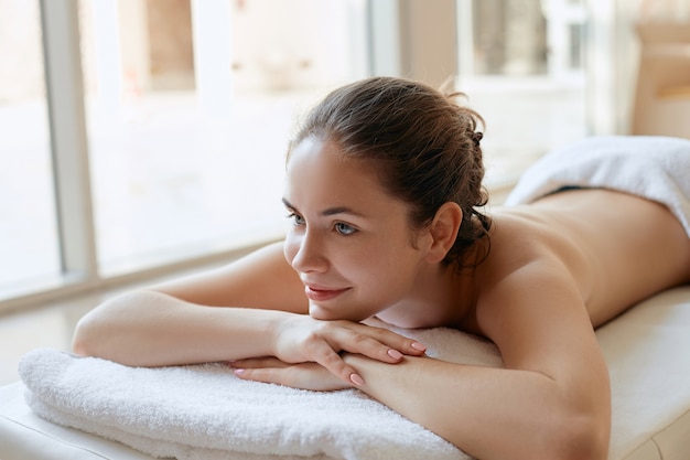 Hermosa mujer relajante en el salón de spa