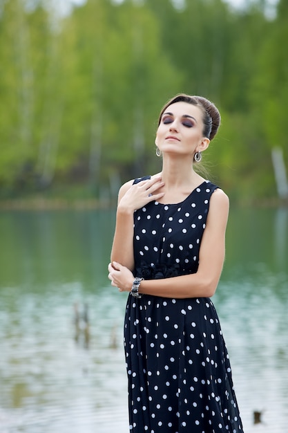 hermosa mujer retro en ropa vintage en el lago