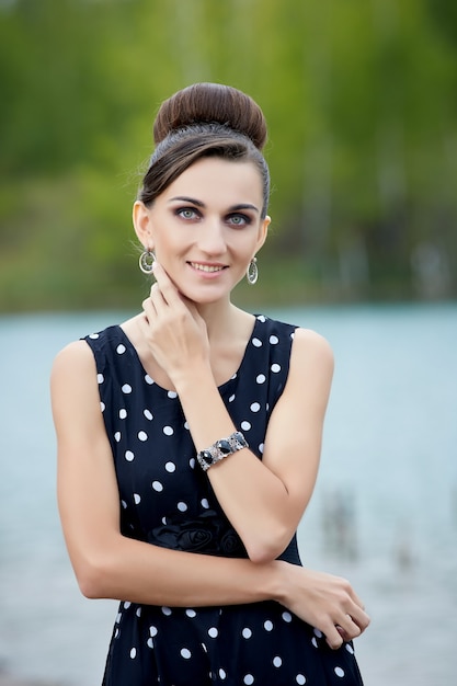 hermosa mujer retro en ropa vintage en el lago