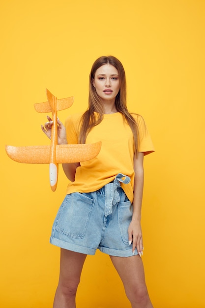 Hermosa mujer en ropa casual un avión en sus manos fondo aislado