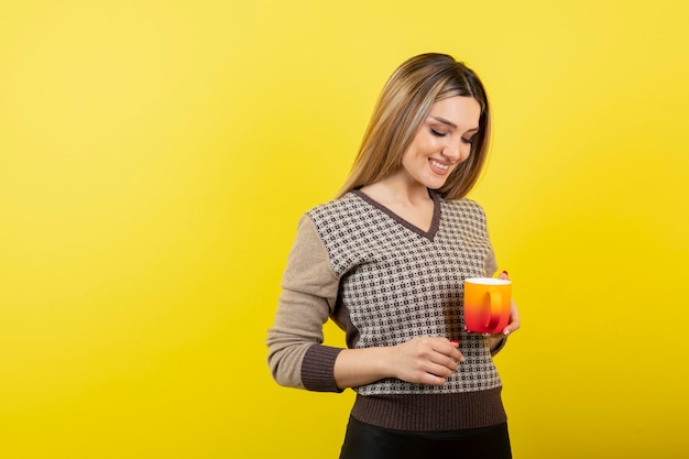 Hermosa mujer en ropa casual sosteniendo una taza de té.