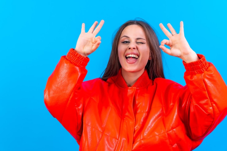 Foto hermosa mujer con ropa informal haciendo un buen cartel con su mano exitosa expresión fondo azul