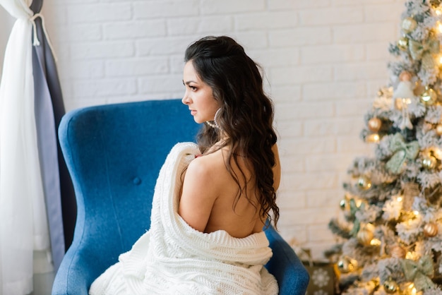 Hermosa mujer en ropa interior cerca de abeto de Navidad en estudio decorado