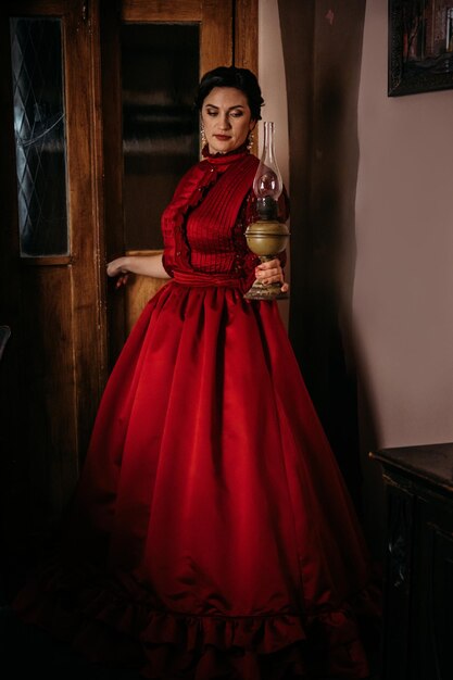 Hermosa mujer en ropa vintage s principios vestido rojo en viejos vestidos históricos interiores vintage