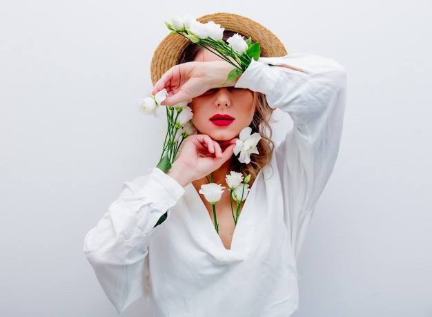 Hermosa mujer con rosas blancas en mangas.