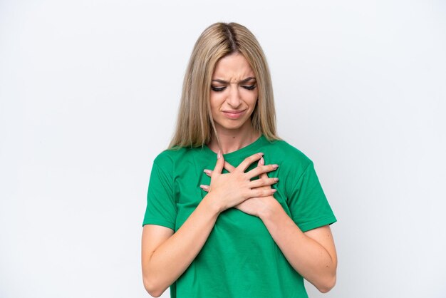 Foto una hermosa mujer rubia aislada sobre un fondo blanco con un dolor en el corazón