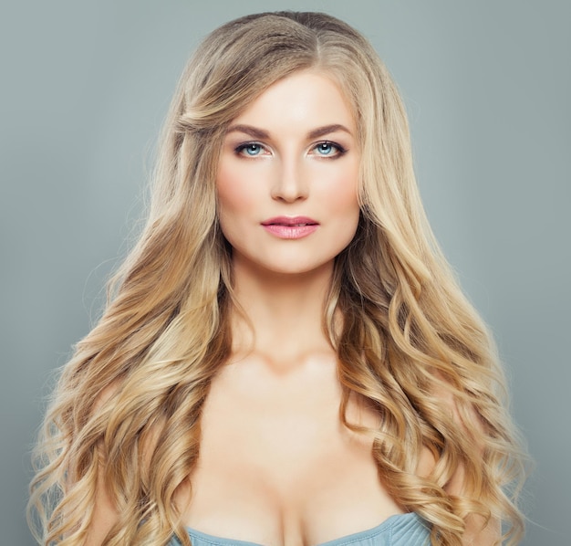 Hermosa mujer rubia con cabello rizado largo y saludable y piel clara Tratamiento facial cuidado del cabello y cosmetología