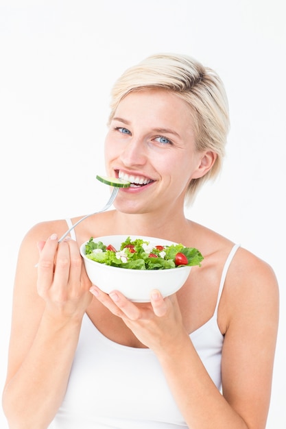 Hermosa mujer rubia comiendo ensalada