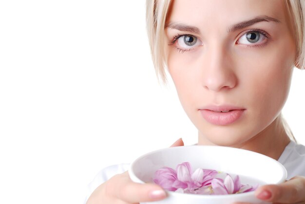 Hermosa mujer rubia con cuenco de flores.