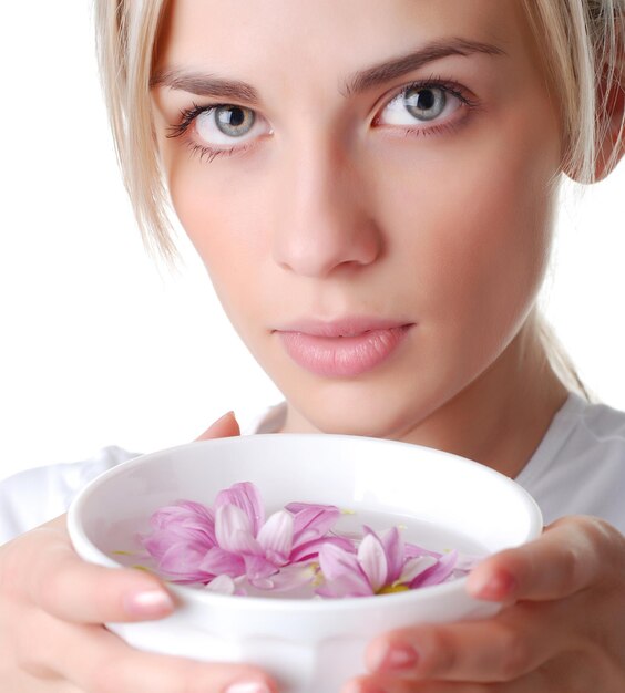 Hermosa mujer rubia con cuenco de flores.