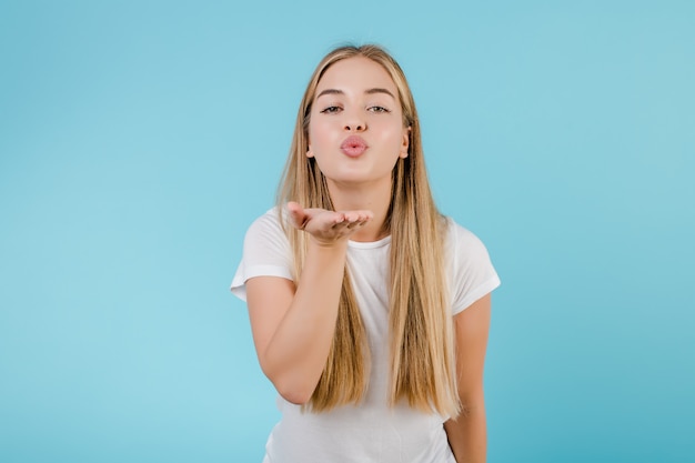 Hermosa mujer rubia enviando beso beso aislado sobre azul