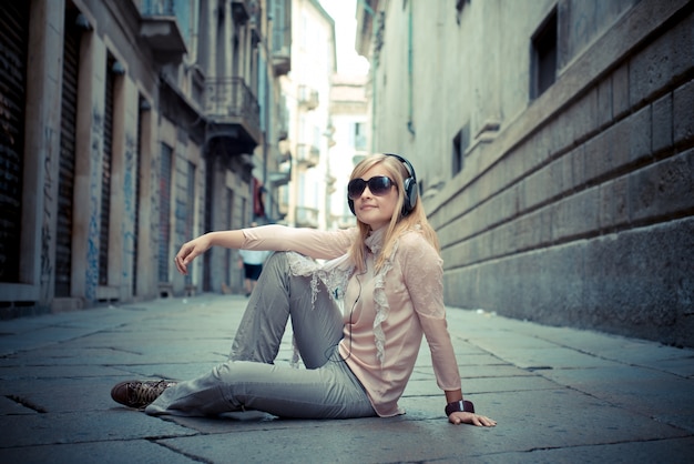 hermosa mujer rubia escuchando música