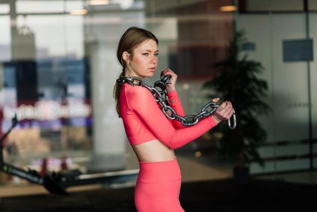 Hermosa mujer rubia en forma muscular ejercicio, construcción de músculos en el gimnasio