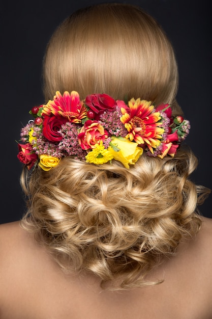Foto hermosa mujer rubia en imagen de la novia con flores. cara de belleza y vista posterior del peinado