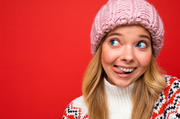 Hermosa mujer rubia joven feliz positiva aislada sobre la pared de colores de fondo vistiendo ropa casual elegante sintiendo emociones sinceras mirando hacia un lado. Copia espacio