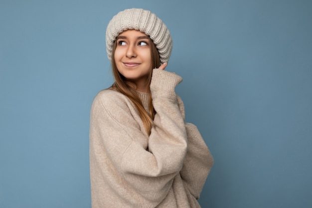 Hermosa mujer rubia oscura joven feliz positiva aislada sobre la pared de colores de fondo vistiendo ropa casual elegante sintiendo emociones sinceras mirando hacia un lado.