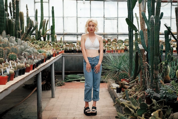 Hermosa mujer rubia posando en el jardín botánico tropical