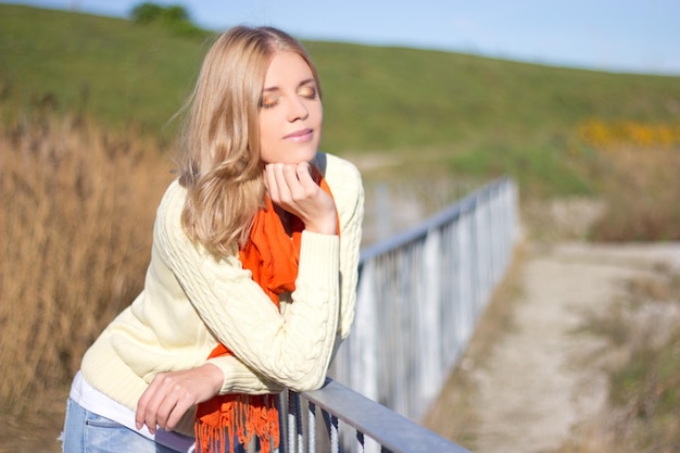 Hermosa mujer rubia posando en el parque otoño