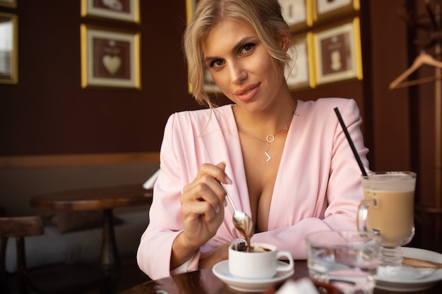 Hermosa mujer rubia sentada en la cafetería