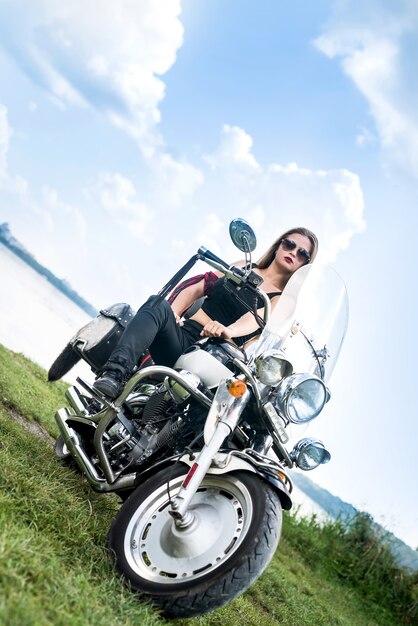 Una hermosa mujer rubia sentada en una motocicleta