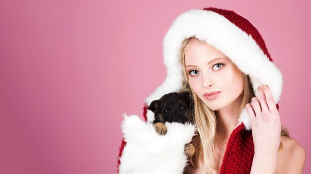 Hermosa mujer rubia con sombrero de piel con cachorrito feliz navidad y feliz año nuevo