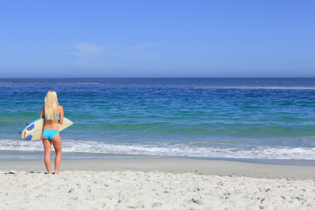 Hermosa mujer rubia con su tabla de surf