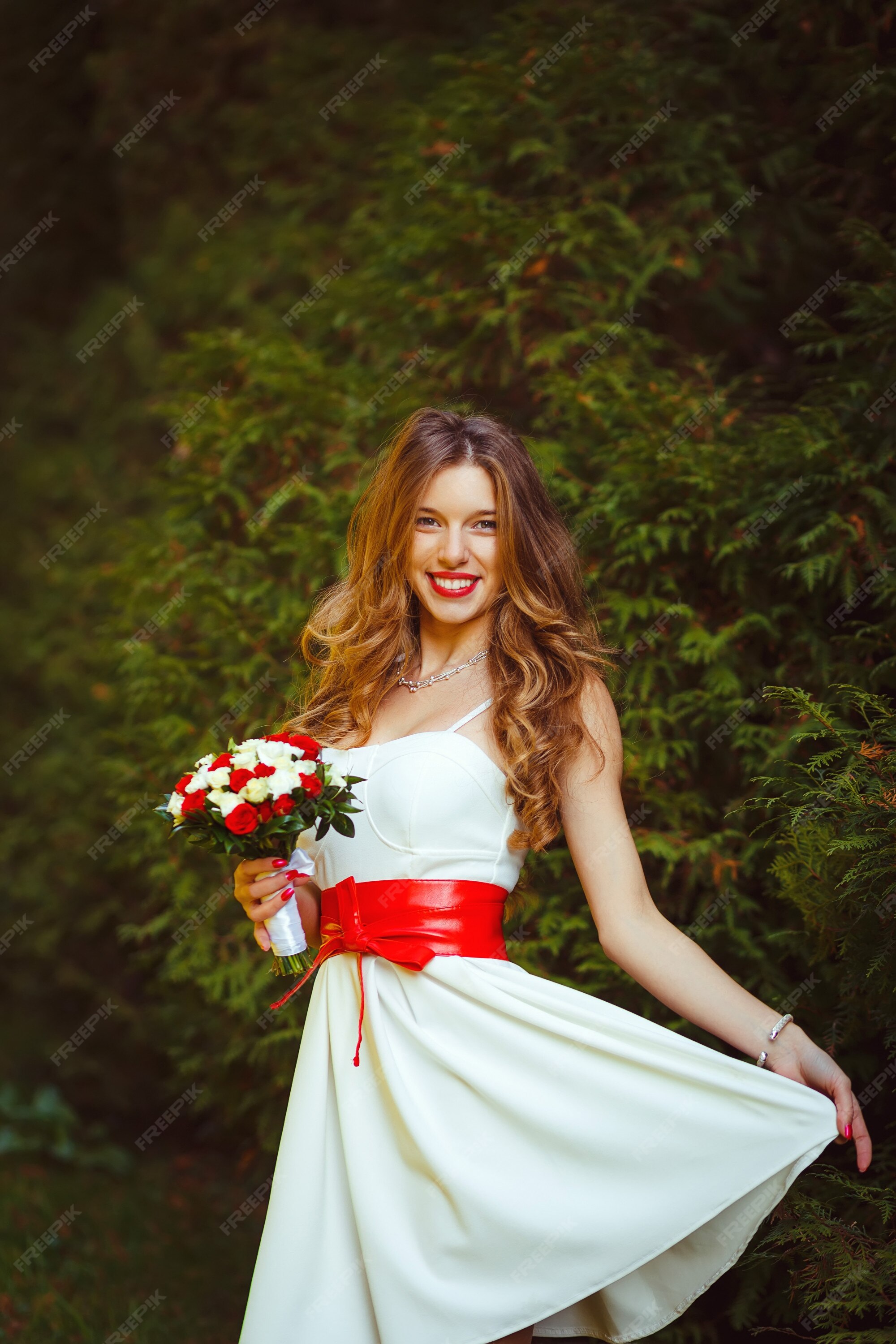 Hermosa mujer rubia en vestido corto blanco lazo rojo posando | Foto Premium