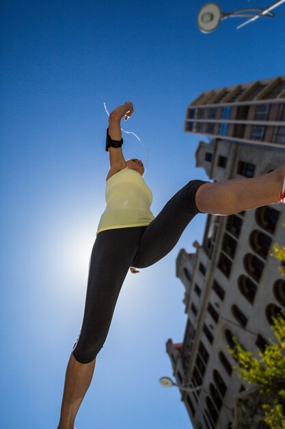 Una hermosa mujer saltando en la calle en un día soleado