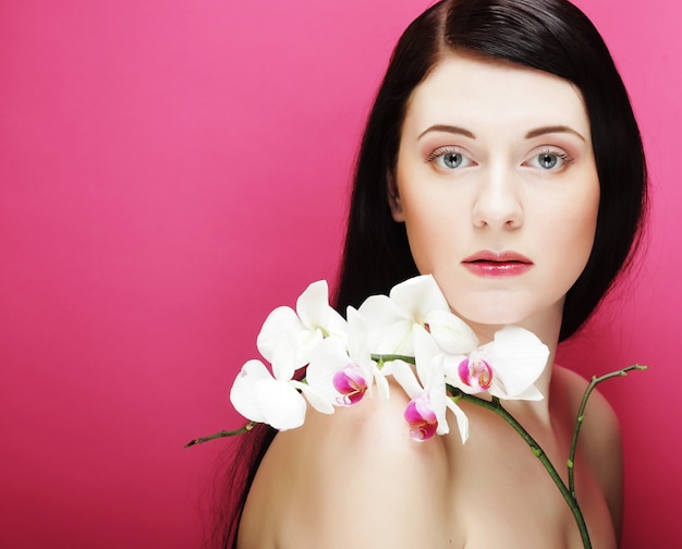 Foto hermosa mujer sana con orquídeas phalaenopsis.