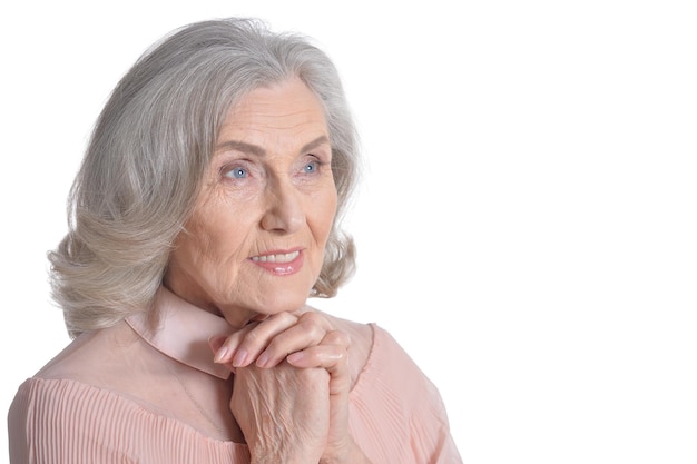 Hermosa mujer senior en blusa rosa aislado sobre fondo blanco.