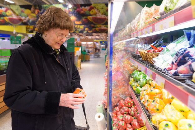 Hermosa mujer senior de compras en el supermercado