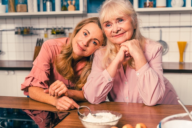 Hermosa mujer senior e hija para hornear en la cocina