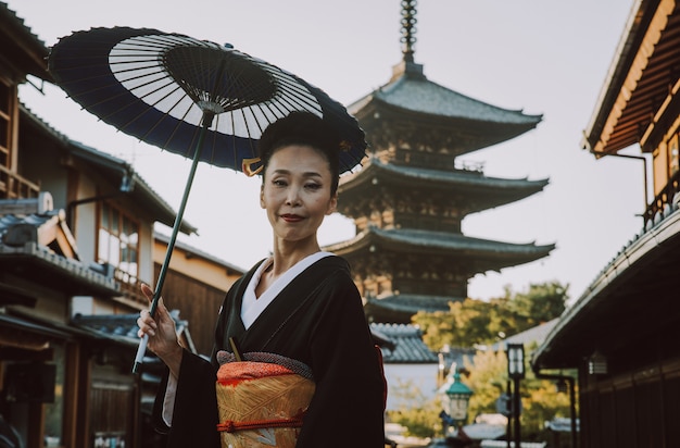 Hermosa mujer senior japonesa caminando en el pueblo. Estilo de vida tradicional japonés típico